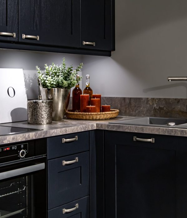 Dark kitchen cabinets with metal pulls or knobs in home interior.